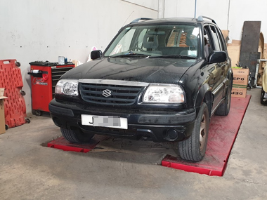 Suzuki Grand Vitara has new headlights fitted and free inspection at our workshop Suzuki Grand Vitara on workshop ramp